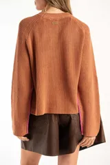 Sweater de punto de algodón con diseño oversize, cuello redondo y mangas largas. Presenta un detalle de costura lateral en color contrastante.