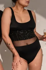 Body negro musculosa escote cuadrado, confeccionado en lycra con detalle de microtul y brillos negros. Breteles anchos y broches en entrepierna con fundillo en algodón 100%.