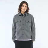 Sobrecamisa de corte recto y diseño estructurado, confeccionada en tejido gris con patrón de rayas verticales finas. Presenta cuello clásico, cierre frontal con botones y dos bolsillos frontales con solapa.