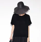 Remera blanca de corte holgado con cuello redondo y flecos en las mangas y el ruedo.