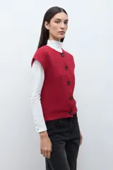 Chaleco tejido de punto acanalado en color rojo, con cuello redondo y cierre frontal de botones oscuros.