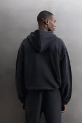 Sudadera con capucha y cierre de cremallera de doble dirección, color negro, de corte relaxed fit, con bolsillos frontales tipo canguro y puños y bajo elásticos.