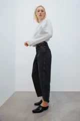 Jeans de tiro medio con diseño de volumen crop y perneras curvas. Presenta cinco bolsillos, cierre frontal con cremallera y botón metálico.