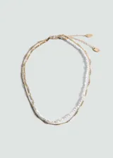 Collar doble dorado, uno con cadena de eslabones y otro con perlas blancas.
