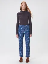 Pantalón de jean de tiro medio con corte de pierna recta y ajuste cómodo. Presenta un estampado integral con motivos geométricos y abstractos en tonos azules.