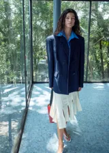Blazer de doble botonadura color azul marino con estampado de raya diplomática, cuello en pico con solapa de muesca, bolsillos con solapa y diseño recto.