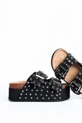Sandalia plataforma de diseño estilo Birkenstock en color negro, con dos tiras ajustables con hebillas metálicas, decoradas con múltiples tachas y ojales plateados.