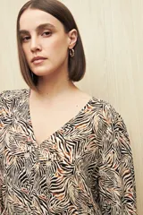 Blusa celeste con estampado floral en tonos beige y marrón, escote en V, mangas 3/4 abullonadas y frunce en la cintura.