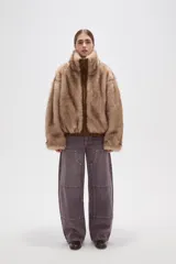 Campera de piel sintética en tono tostado, con cuello alto, cierre frontal y diseño holgado.