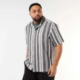 Camisa de manga corta a rayas verticales en tonos negro y blanco, con cuello camisero, cierre frontal de botones y un bolsillo aplicado en el pecho.
