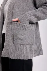 Cardigan gris claro de tejido de punto con bolsillos delanteros y lazo al cuello.