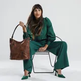 Cartera estilo hobo color marrón, confeccionada en material símil cuero con textura. Presenta dos bolsillos frontales con cierre metálico, apertura superior con cierre y asa corta para el hombro.