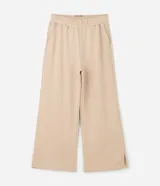 Pantalón de corte wide leg en color beige, con cintura elástica, bolsillos laterales y abertura en el ruedo. Confeccionado en tejido de algodón y poliéster con caída amplia.