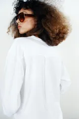 Camiseta oversize de manga larga color rosado, con cuello redondo y bajo recto.