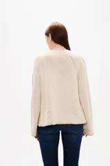 Cardigan de punto color natural, con cuello en V, cierre frontal con botones y diseño holgado. Presenta detalles de costuras decorativas bordadas a lo largo de las mangas y en los bordes.