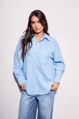 Camisa oversize de lino y viscosa color celeste, con cuello clásico, cierre frontal con botones y mangas largas.