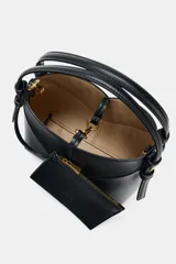 Mini bolso tipo shopper confeccionado en material trenzado color beige, con detalles en cuero sintético marrón. Cuenta con asa de mano fija y correa bandolera extraíble, además de una cartera interior con cierre.