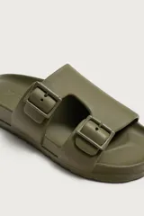 Sandalia de estilo casual en color verde militar con acabado engomado, dos tiras anchas en el empeine ajustables con hebillas y plantilla anatómica.