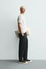 Pantalón de corte carrot fit confeccionado en tejido de algodón con estructura diagonal y efecto lavado. Presenta bolsillos frontales con bolsillo cerillero, bolsillos traseros de plastrón y cierre frontal con cremallera y botón.
