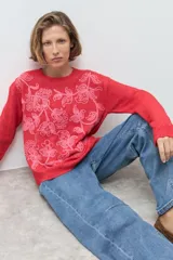 Sweater de punto color rojo con cuello redondo, mangas largas y bordado floral en tono rosado en la parte frontal.