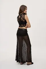 Falda larga de encaje negro semitransparente, de tiro medio y diseño amplio con textura floral.