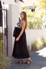 Sandalias de cuero negro con diseño de tiras entrecruzadas, hebilla dorada y suela plana.