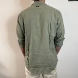 Camisa de manga larga confeccionada en lino, color blanco, con cuello clásico y cierre frontal de botones.