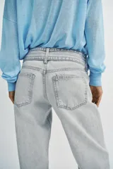 Jeans de corte recto y tiro bajo, confeccionados en tejido de algodón. Presentan diseño de cinco bolsillos, cierre frontal con cremallera y botones, y detalle de cinturón integrado en la cintura.