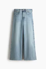 Jean tobillero de denim de algodón con leve stretch, piernas amplias, tiro alto, bolsillos parche delanteros con botón y corte holgado de muslo a bajo.