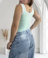 Musculosa verde agua ajustada al cuerpo, con escote cuadrado y ribetes blancos en cuello, sisas y bajo busto. Incluye copas.