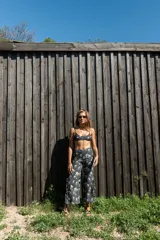 Conjunto de bikini negro con estampado de calaveras, labios, zapatillas y texto "Rock'N'Roll" en blanco y rojo. El top es de corte triangular con breteles finos regulables y la bombacha es colaless de tiro medio a alto.