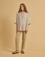 Camisa de corte oversize en color beige, con cuello solapa, cierre frontal de botones y mangas 3/4.