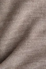 Buzo de punto fino suave color marrón, con mangas tres cuartos, cuello alto acanalado, hombros caídos y remates acanalados en puños y bajo.