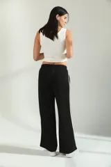 Pantalon de jogging de corte amplio y tiro medio, color gris melange, con cintura elástica y detalle de franjas laterales en tono claro.