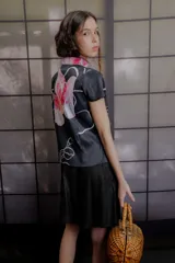 Top de tafeta verde con estampado floral en tonos azules y bordó, cuello mao, mangas cortas y cierre lateral cruzado con botones.