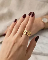 Anillo ancho de bronce con baño de oro, acabado texturizado y diseño decorado con piedras naturales en tonos rojos, verdes y azules.