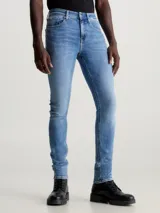 Jeans de hombre, corte skinny, talle bajo, con lavado azul medio vintage y efecto ligeramente desgastado. Confeccionados con algodón reciclado.