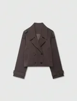 Chaqueta corta de color marrón chocolate, con diseño de doble botonadura, solapas amplias y charreteras en los hombros. Presenta mangas largas con puños ajustables mediante trabillas y bolsillos laterales integrados.