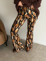 Pantalón tipo oxford de tiro alto, con estampado abstracto en tonos tierra, negro y crema. Presenta un corte ajustado en la parte superior y acampanado desde la rodilla hacia abajo.