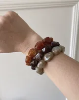 Pulsera elástica con cuentas asimétricas de acrílico efecto mármol en tonos marrones y beige.