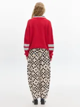 Sweater marrón de punto con cuello polo, escote en V y mangas largas con puños acanalados.