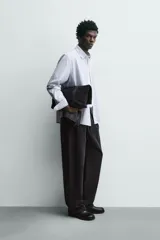 Camisa de corte regular fit confeccionada en tejido de algodón con diseño de rayas verticales. Presenta cuello abotonado, manga larga con puños abotonados, bolsillo plastrón en el pecho y cierre frontal con botones.