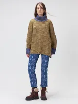 Pullover de punto jacquard color tostado con cuello alto y puños acanalados en tono azul y detalles en naranja. Cuenta con aberturas laterales y calce holgado.