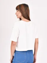 Remera blanca de corte crop con mangas cortas y cuello redondo. Estampado frontal con la frase "Pilates, Matcha, Inner Peace, Repeat".