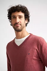 Sweater de tejido de punto con escote en V y manga larga. Presenta un diseño de calce regular con puños y ruedo acanalados, e incluye un pequeño logo bordado en el pecho.