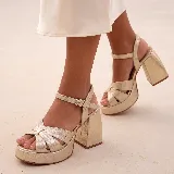Sandalias de cuero color gris plateado con plataforma, taco ancho y tira ajustable al tobillo con hebilla metálica.