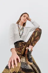 Pantalón tipo babucha de tejido grueso con estampado de piel de serpiente en tonos marrones y negros, con pretina ancha negra.