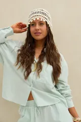 Camisa de rayas celestes y blancas, con cuello clásico, cierre frontal con botones y bolsillo ojal en el pecho.