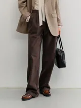 Pantalón sastrero de pierna ancha color marrón oscuro, con doble pinza frontal y calce fluido.