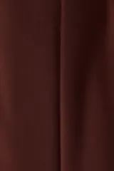 Pantalón acampanado de color bordó, de talle alto con pretina prolongada y cierre oculto. Presenta bolsillos al bies en los laterales, bolsillos decorativos en la parte trasera y perneras amplias con pliegues marcados tanto en el frente como en la espalda.